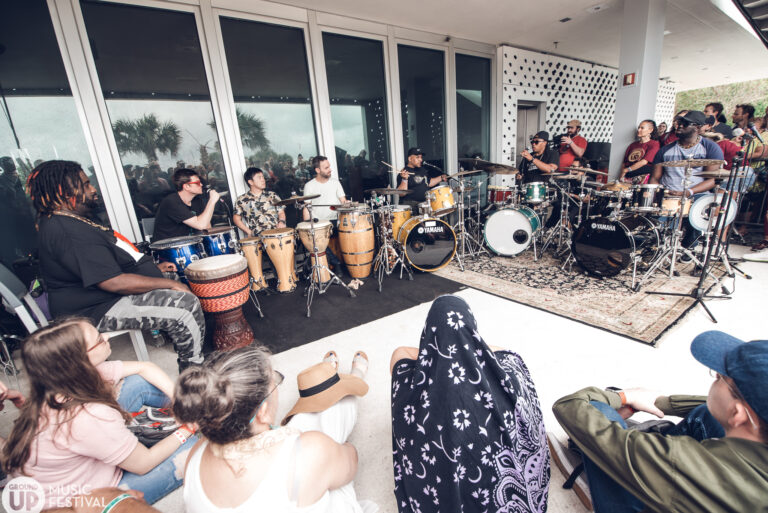 a group of people sitting around a drum set