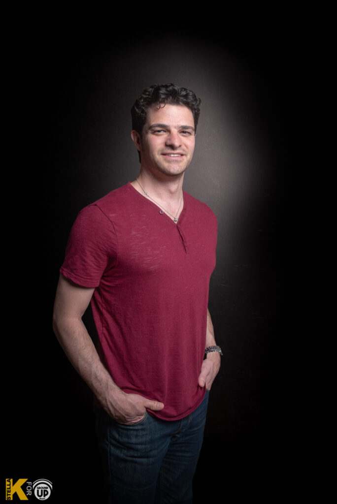 a man in a red shirt posing for a picture