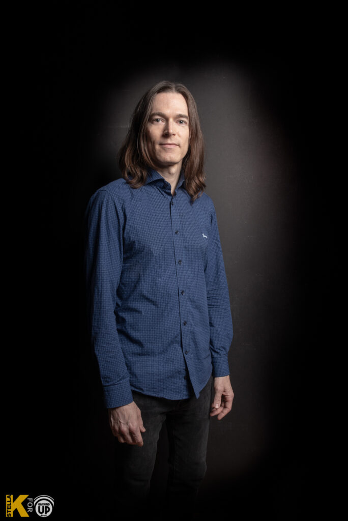 a man in a blue shirt posing for a picture