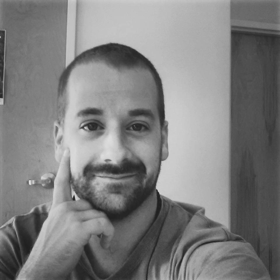 a black and white photo of a man smiling