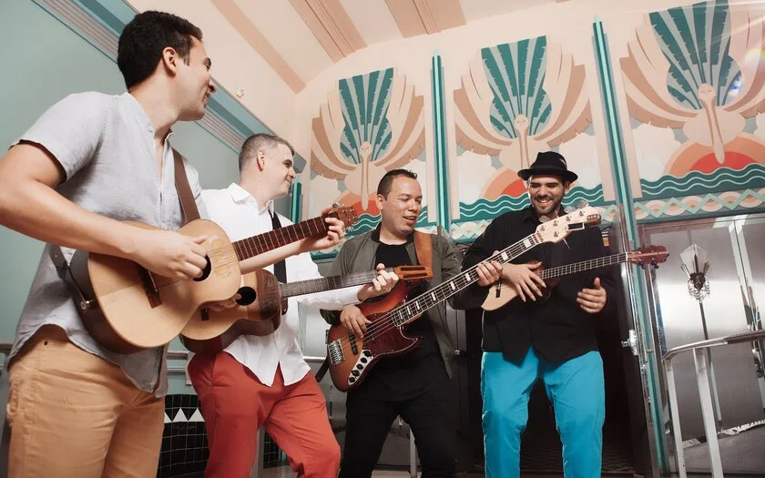 a group of men playing guitars in a room