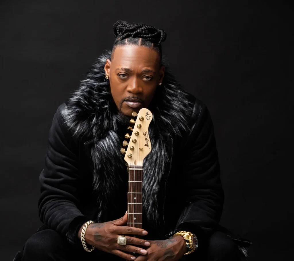 a man in a fur coat holding a guitar